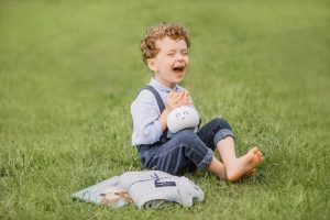 laughing, one person, barefoot, color image, sitting, grass, outdoors, happiness, child, nature, enjoyment, childhood, portrait, cute, carefree, playful, horizontal, vitality, toddler, brown hair, fun, 2-3 years, looking at camera, growth, focus on foreground, smiling