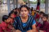 A young teacher sits with her students in an outdoor classroom in Rangpur, Bangladesh.