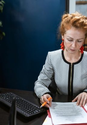 pexels photo 6172493 6172493 A focused woman working on paperwork in a modern office environment.